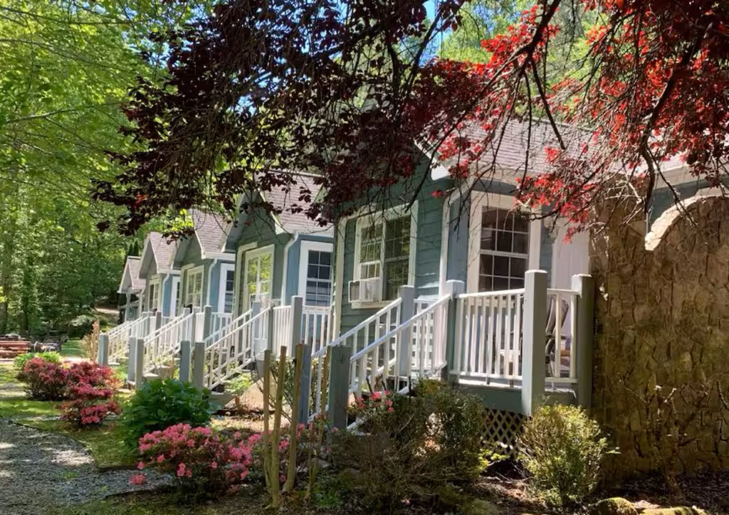 The Old Blue Boar Inn in Robbinsville: a row of blue cottage-style rooms with white porches under a red-leafed tree